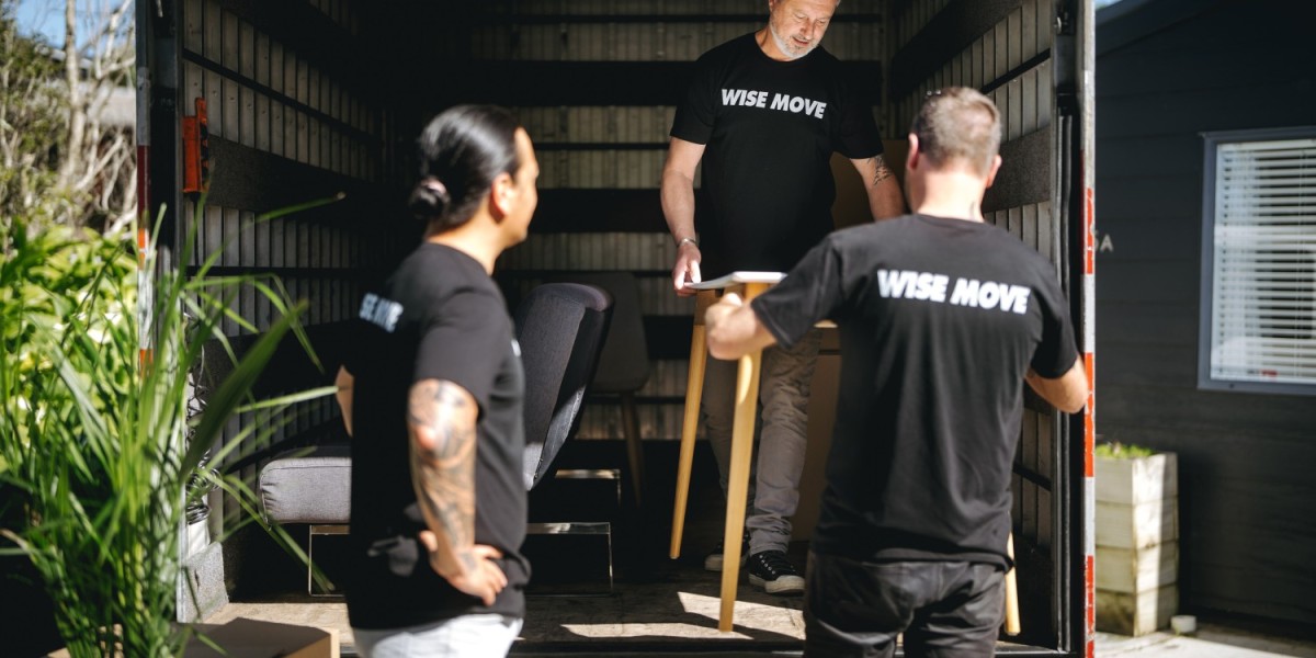 Movers carefully loading a table into their moving truck