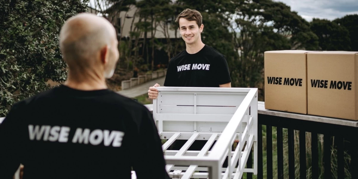 Two movers carrying a bed frame