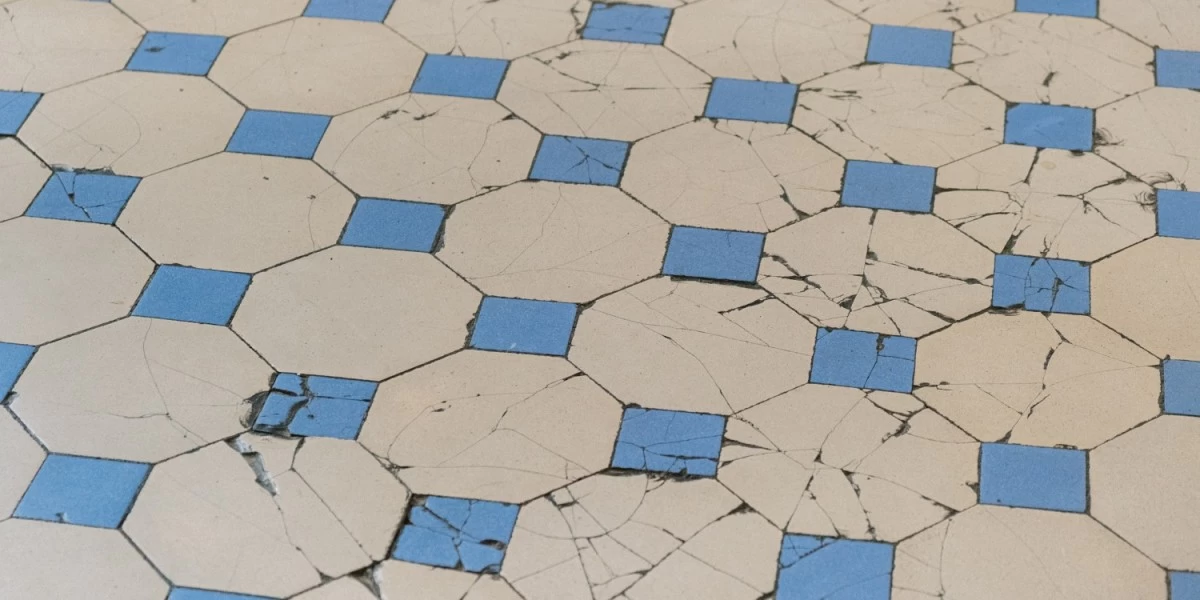 A broken tiled floor at a rental place that can be easily covered up with peel-and-stick tiles, giving your rental home an affordable makeover