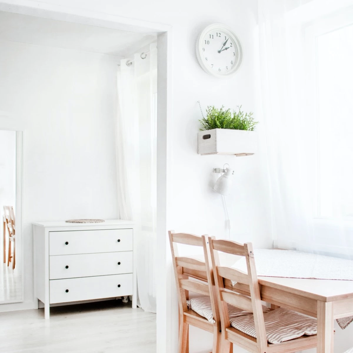 A minimalist room, with white walls and wooden floors. All of the furniture is stylish yet minimal, and there is a natural, calming energy to the space