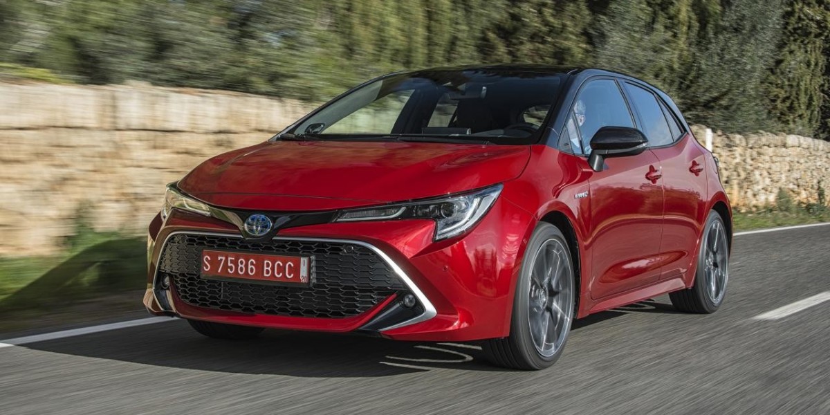 A bright red Toyota Corolla sedan, a popular model in New Zealand and is widely used as a family and city car.