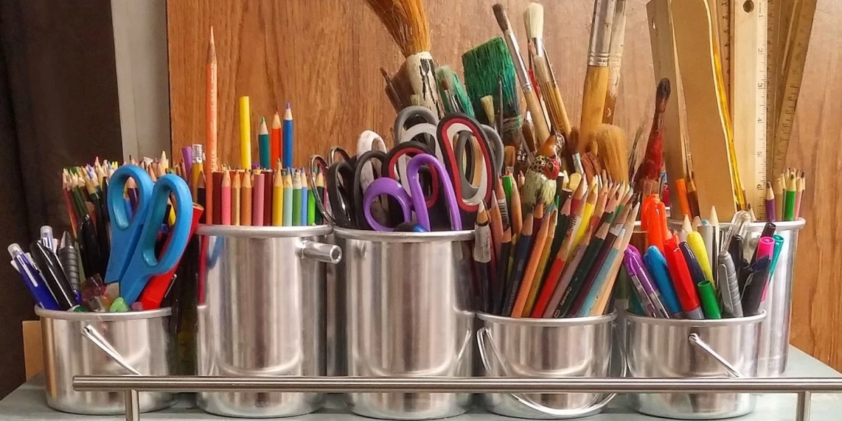 A collection of various colored pencils, pens, dried-up paint brushes and other art work materials that's been rarely used and taking up storage space 