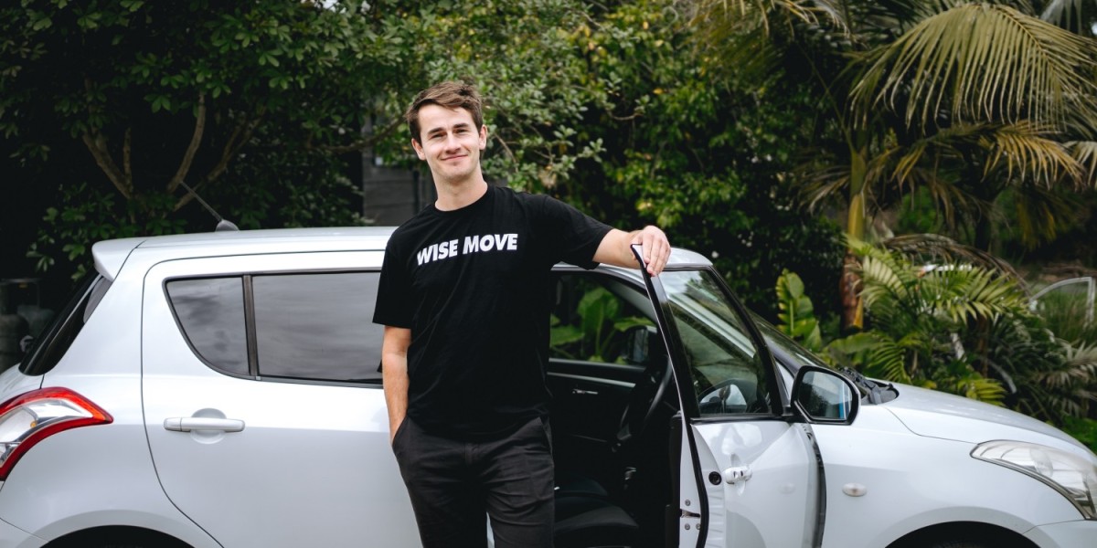 A man standing next to a white car, while holding its passenger door open