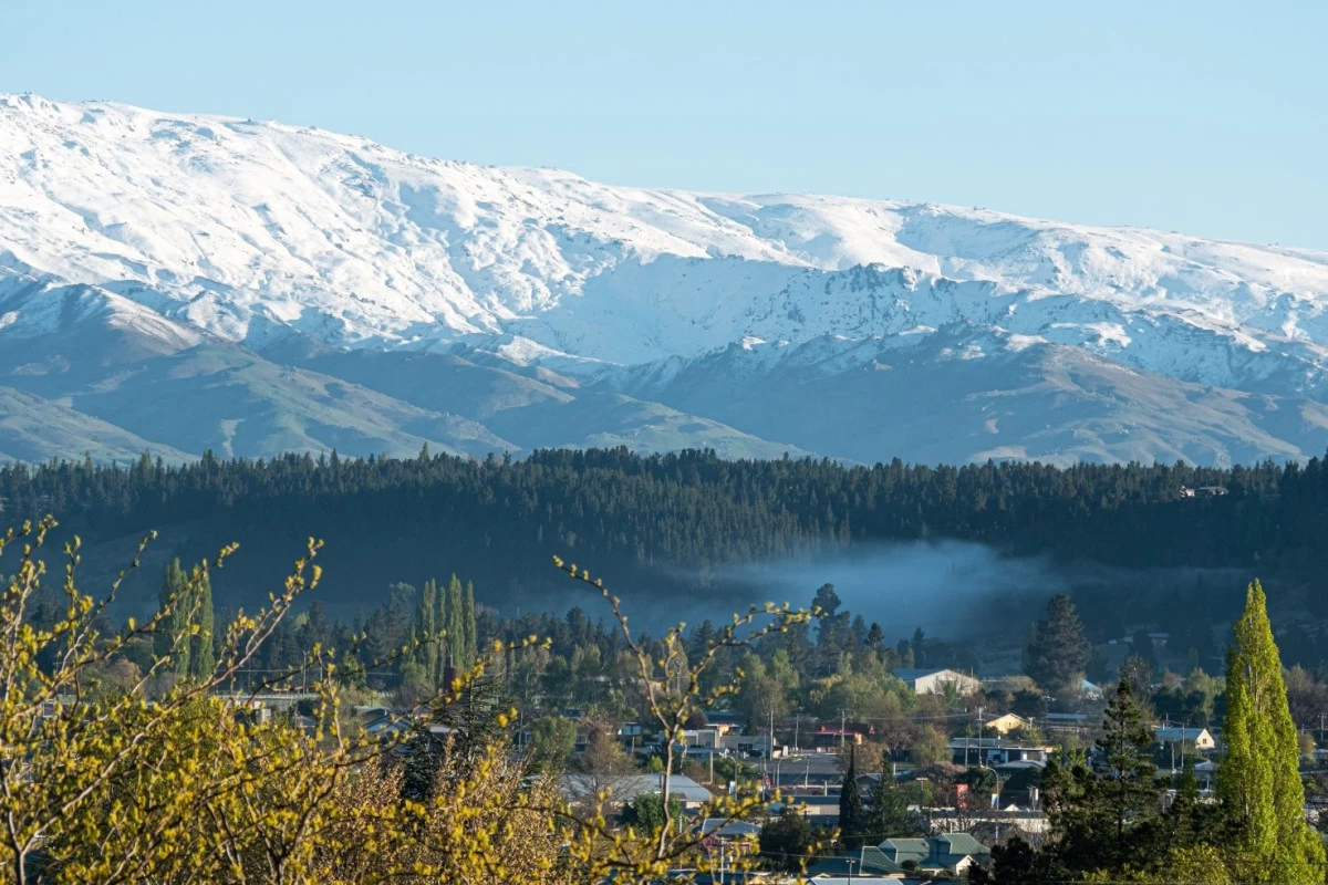 Alexandra, with a view of the snow-capped mountains in the background. Alexandra is a picturesque and affordable alternative to nearby tourist towns.