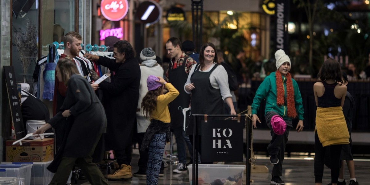 Few men and women checking displays of used clothings at Koha Apparel