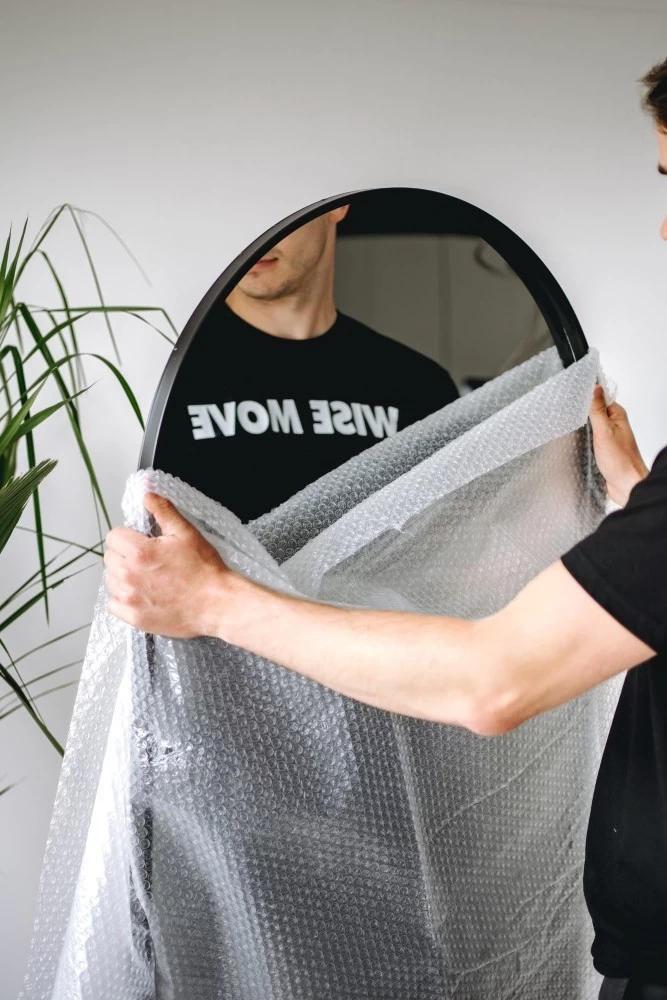 A mover holding a bubble wrapped mirror