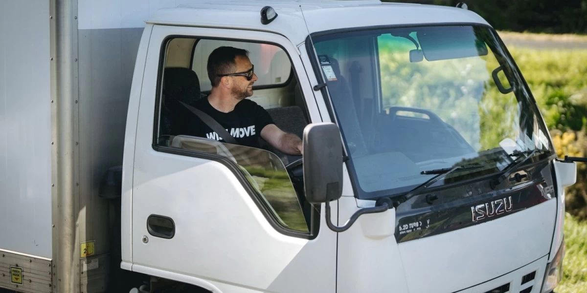 A mvover driving his moving truck to an available parking spot
