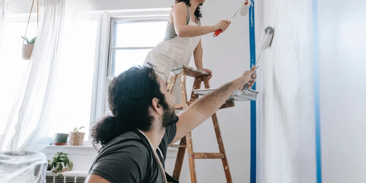 A young couple repainting the wall of their new home