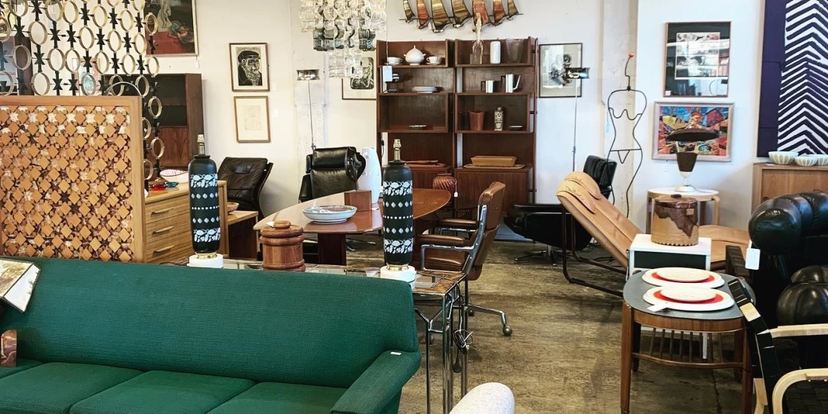 A green couch and various other second-hand furniture pieces are on display at Mr Mod store in Christchurch. Other items include storage solutions, coffee tables, and retro seating for an affordable price.