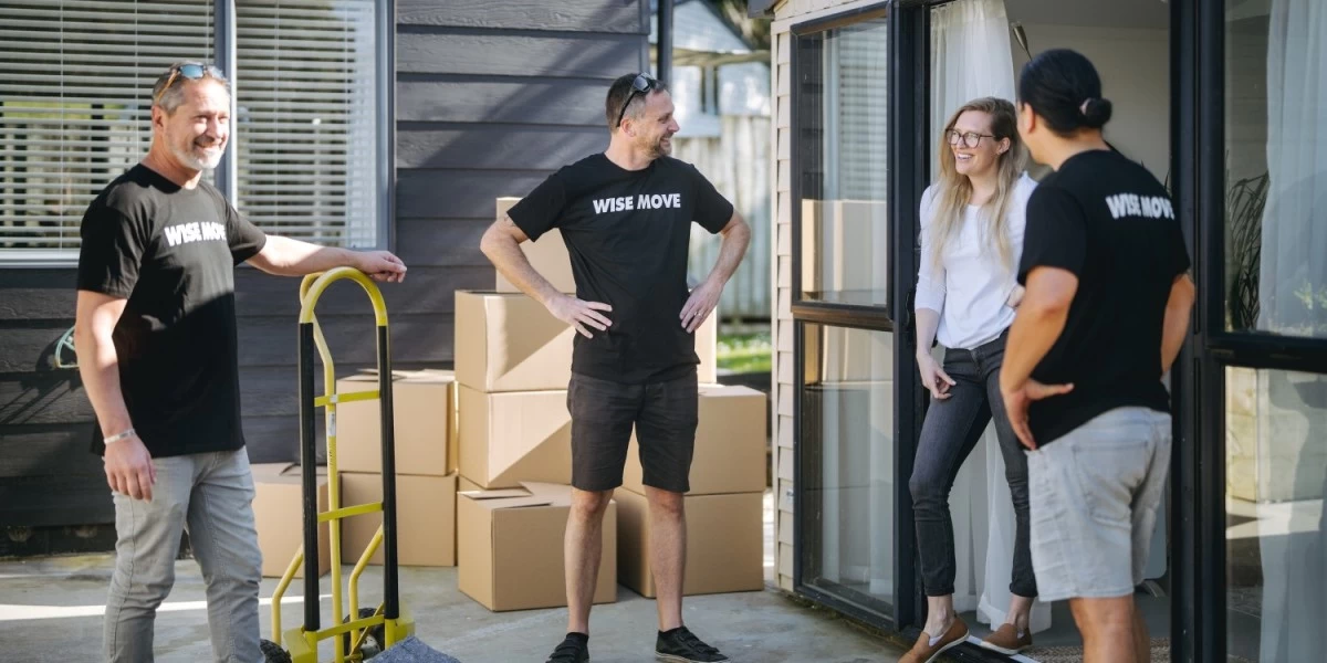 Three movers chatting with the lady homeowner they had help moved in to her new home