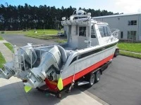 Small boat 7.3m Bladerunner power cat on trailer coupled to Massey Fer...