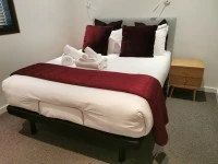 Queen bed, 2 small bedside tables, small 2 seater dining table and 2 c...