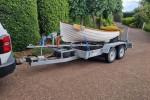 Small boat 10ft dinghy on a beach trailer.