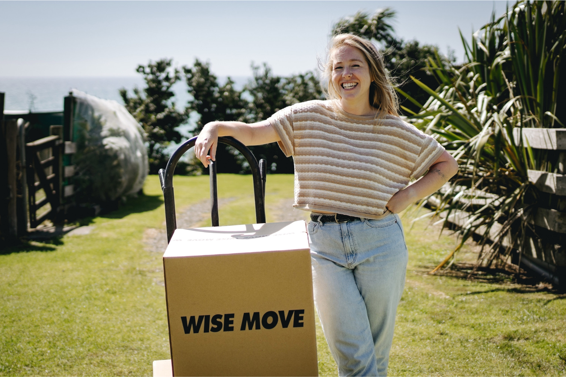 Student standing outside with a Wise Move box during a flat move in New Zealand