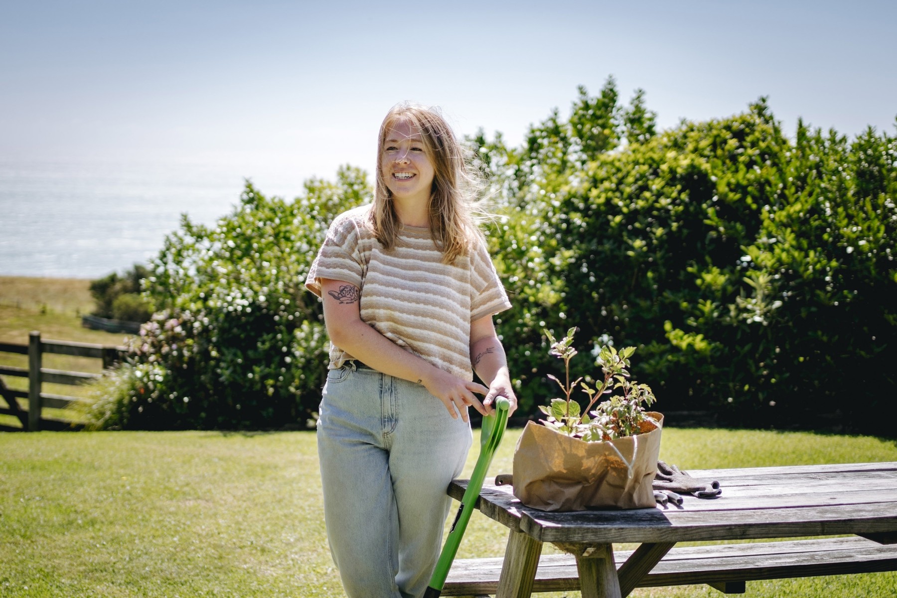Woman standing next to herbs on table about to be planted