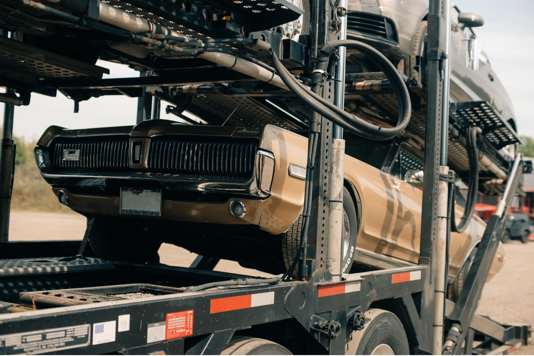 Industrial carrier powered day cab big rig black car hauler semi-truck tractor transporting cars and crossovers