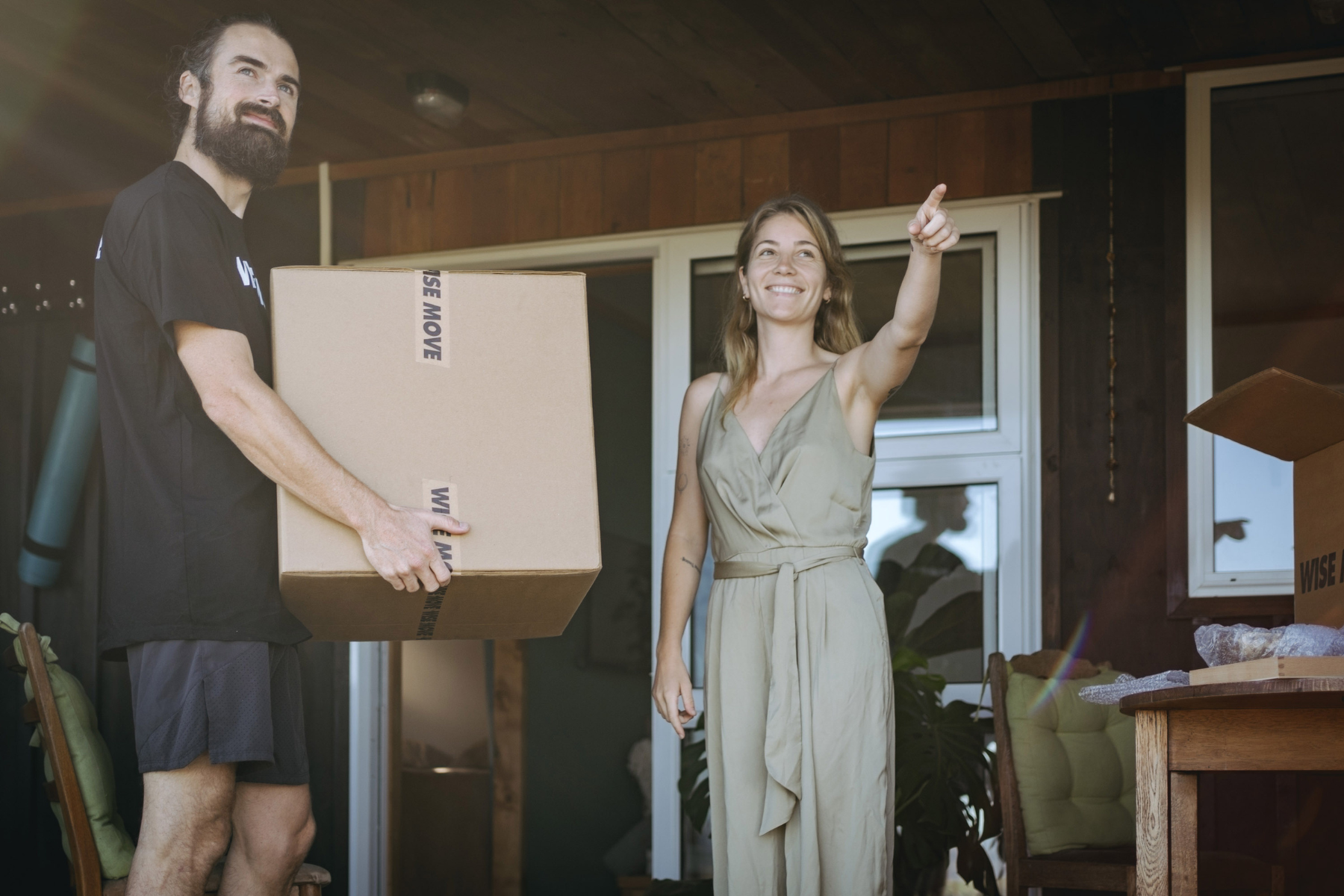 Student directing student movers holding a moving box