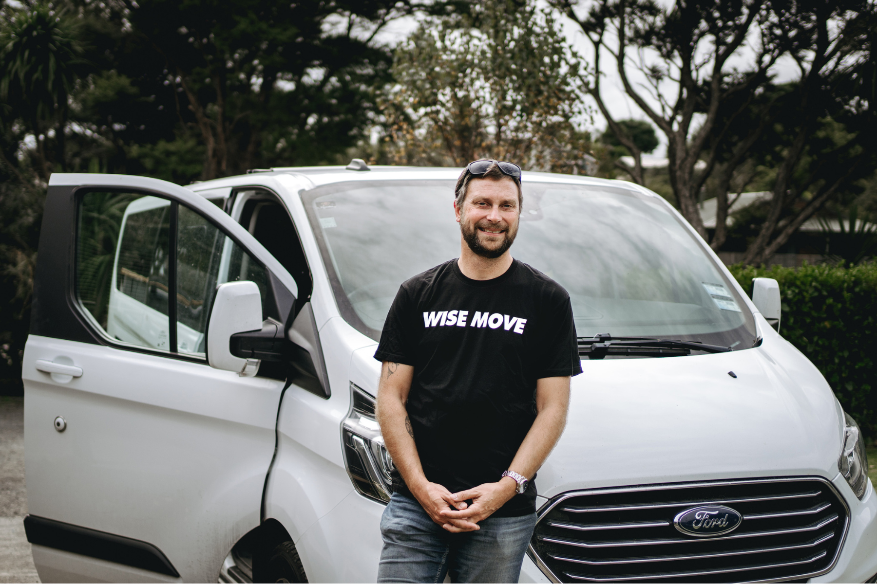 Wise Move driver standing in front of a white car for transportation
