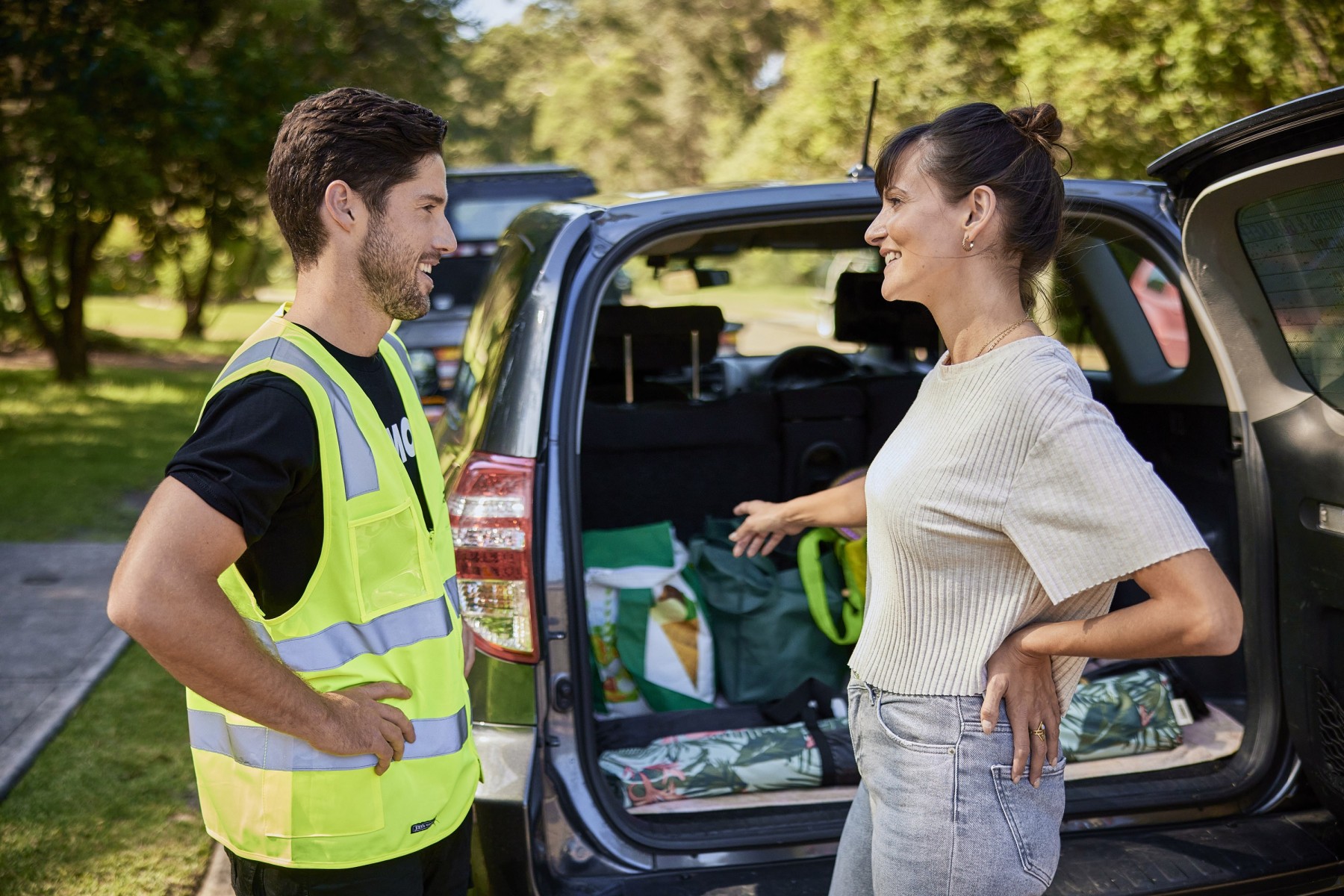 Woman speaking to car transport team with car boot full