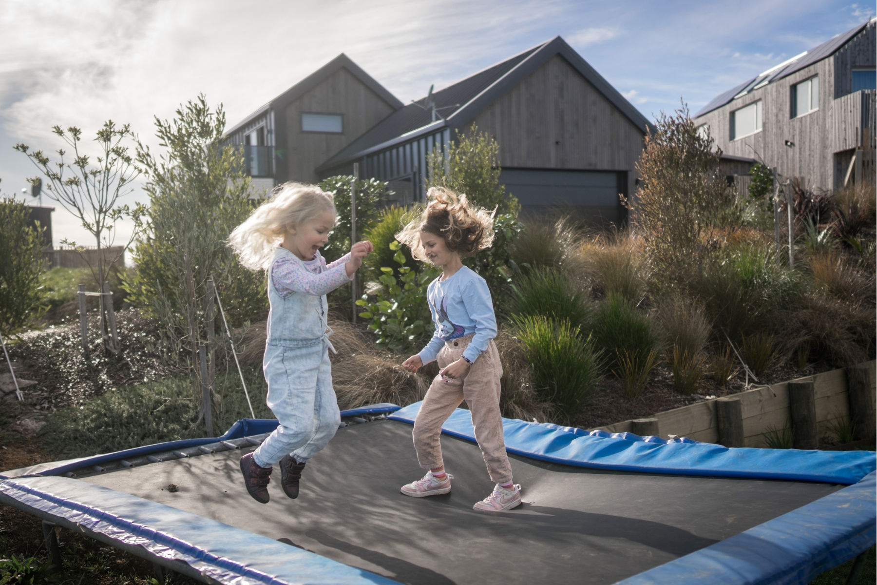 Two young children playing on a trampoline at childcare in New Zealand
