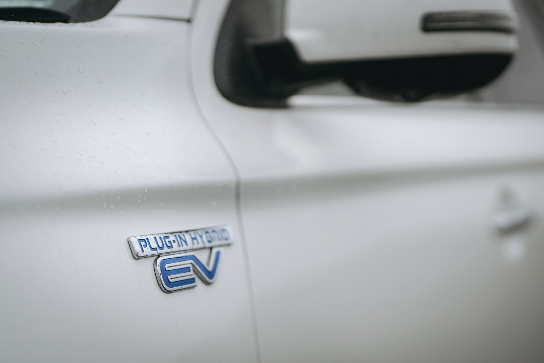 Plug-in hybrid EV badge on white SUV close-up