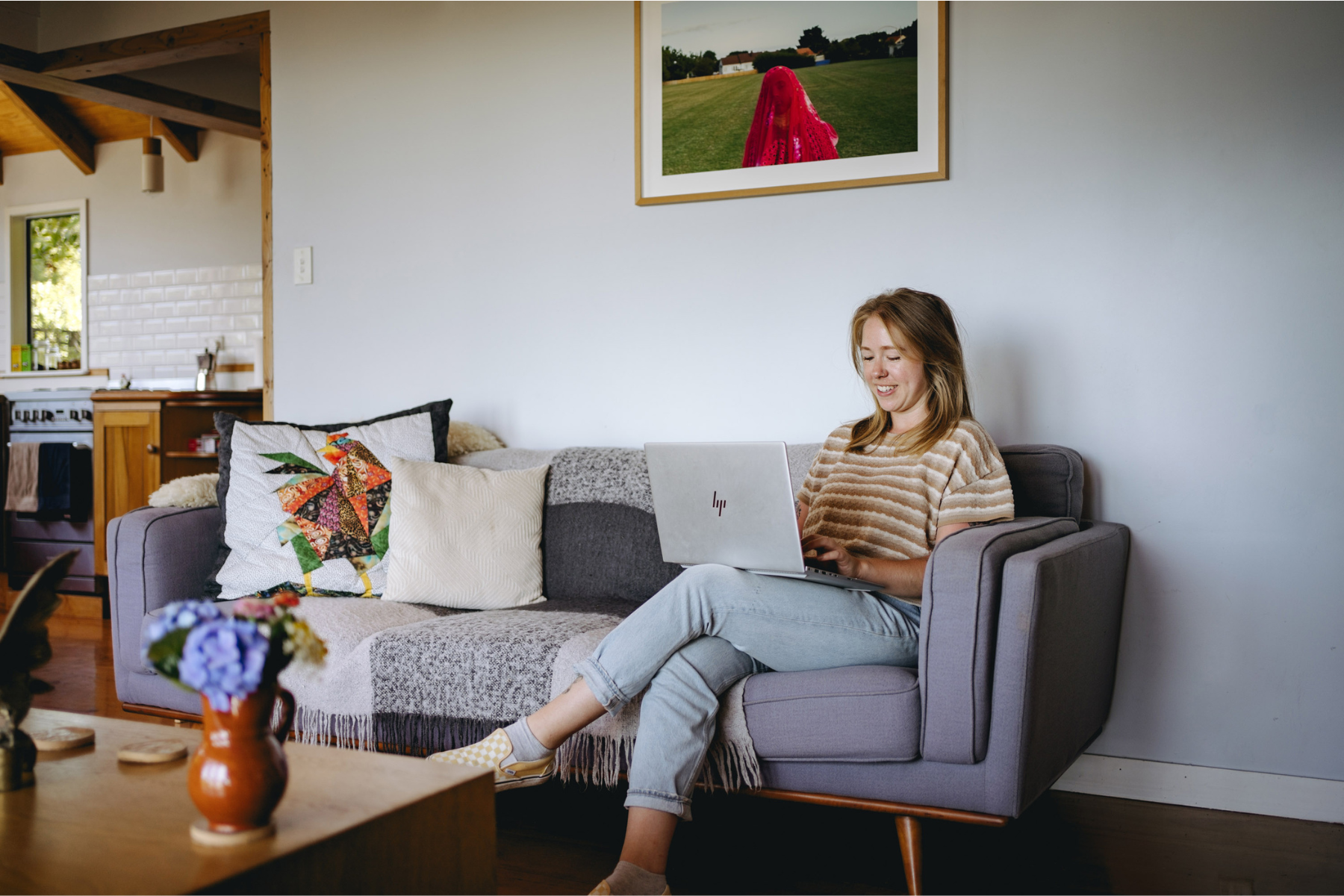 female student sitting on couch on her laptop planning her student move