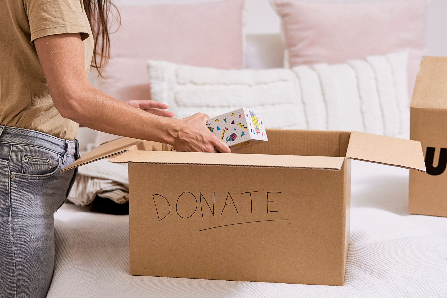 Sorting items into donation box during home decluttering