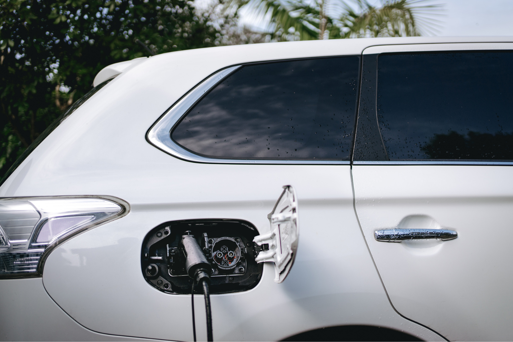 EV charger inserted into EV charging port at home.