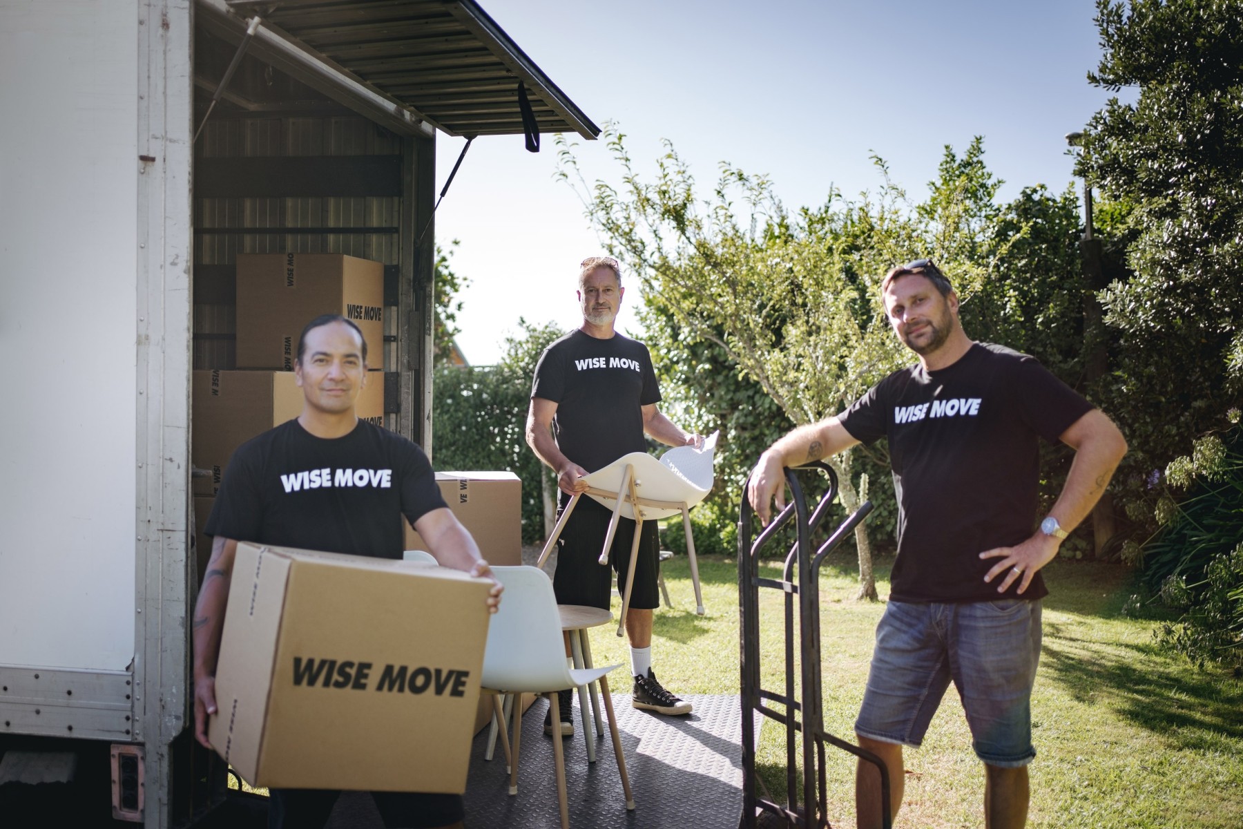 Local Wise Move moving team unloading furniture and boxes from truck.